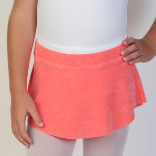 A young ballerina wears a bright coral flowy Bullet Pointe ballet skirt.