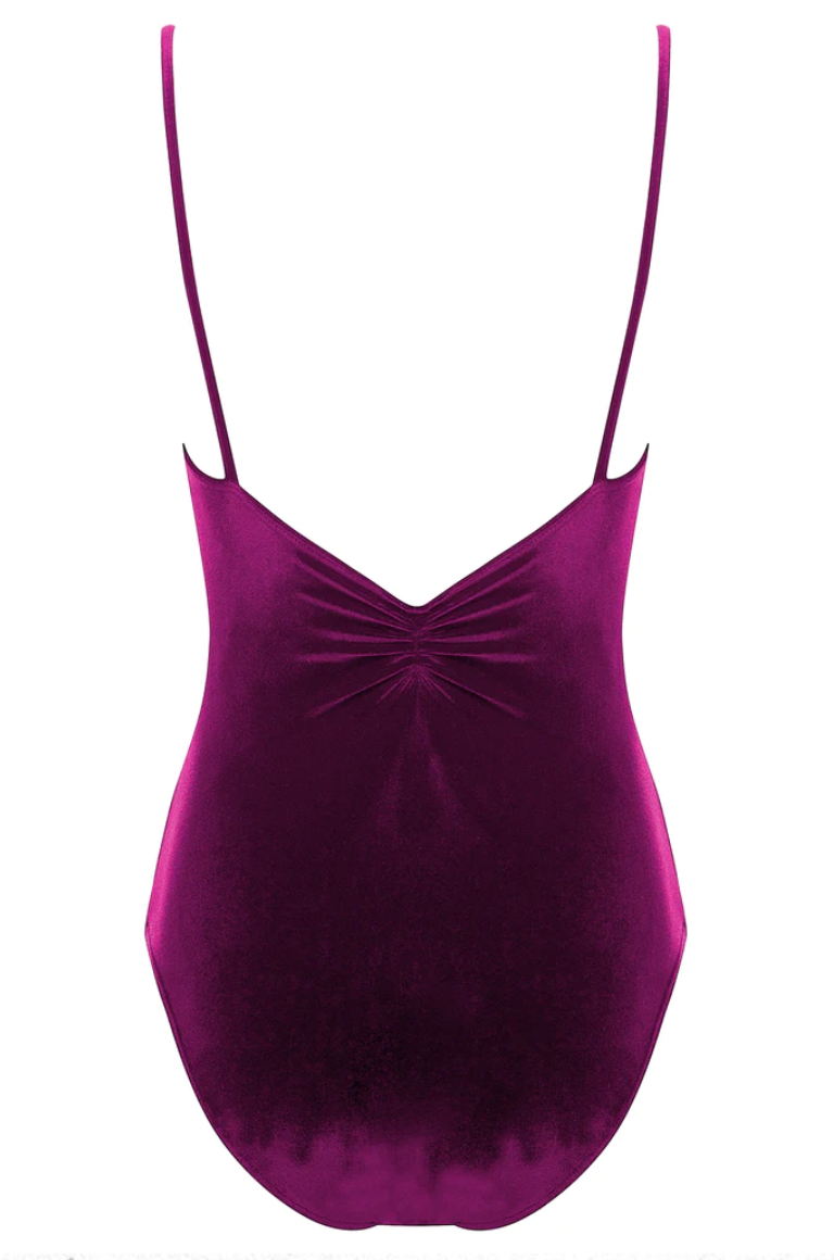 The back of a deep raspberry colored velvet leotard with a pinch detail at the center of the back and spaghetti straps.