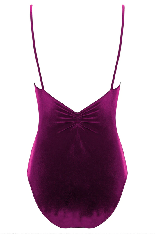 The back of a deep raspberry colored velvet leotard with a pinch detail at the center of the back and spaghetti straps.