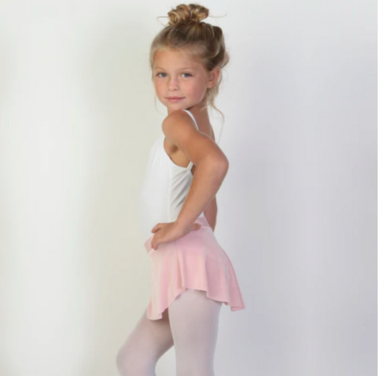 A young ballerina wears a soft, light pink flowy Bullet Pointe ballet skirt. 